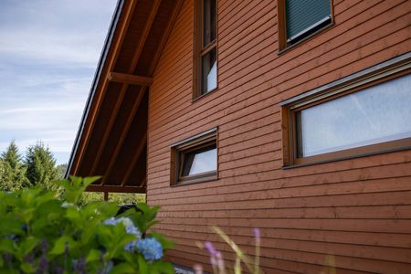 Holzfassade eines Hauses mit Fenstern