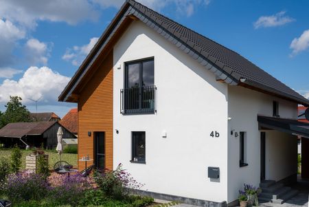 Einfamilienhaus Lichtenau – klare Linien, starke Materialien Modernes Einfamilienhaus in Lichtenau mit Holz-Putz-Fassade, schwarzem Satteldach und Hausnummer 4b – geplant und realisiert von Wiese und Heckmann